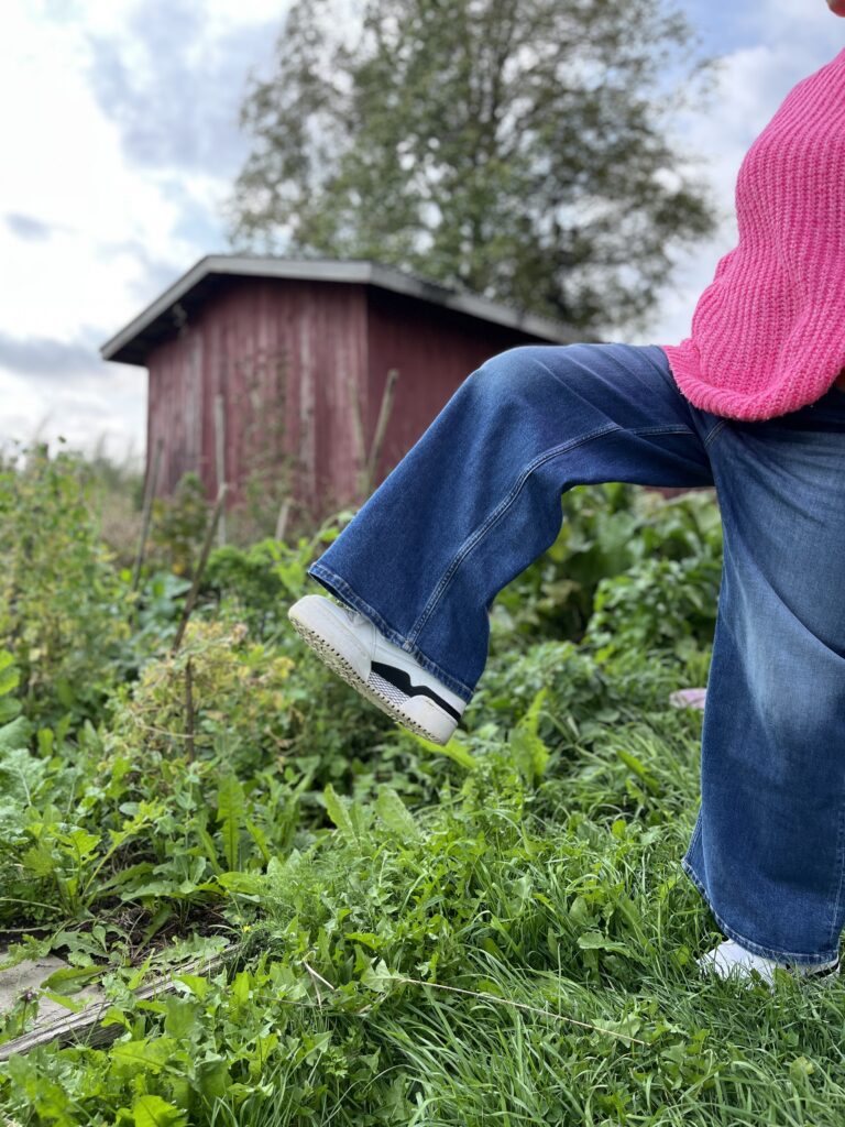 Saana kävelee isolla askelmalla, värikäs paita ja tennarit 